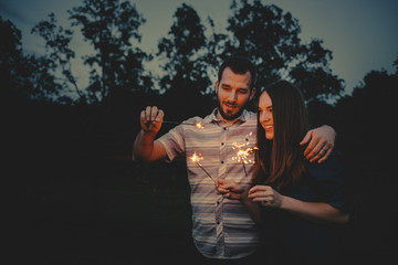 Obraz na płótnie Canvas Loving Couple doing Sparkler Fireworks Together