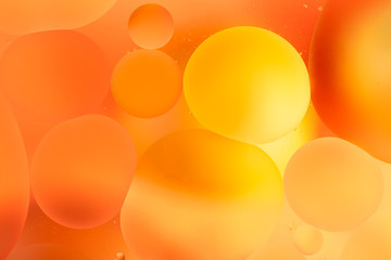 oily drops in water with colorful background, close-up 