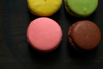 Multi-colored macaroons on a wooden tray. Pink, yellow and green macaroon. - 272862604