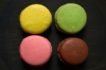 Multi-colored macaroons on a wooden tray. Pink, yellow and green macaroon. - 272862613