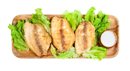 top view of fried ocean perch fillet on wood tray