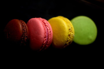 Multi-colored macaroons on a wooden tray. Pink, yellow and green macaroon. - 272862624