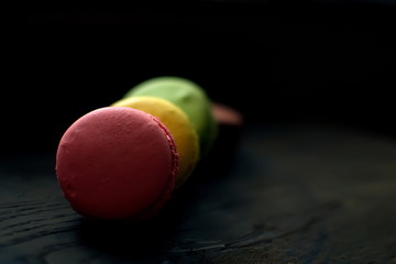Multi-colored macaroons on a wooden tray. Pink, yellow and green macaroon. - 272862673