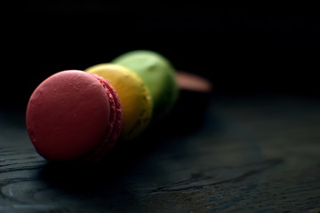 Multi-colored macaroons on a wooden tray. Pink, yellow and green macaroon. - 272862691