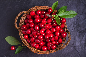 Fresh cherries in basket on black background. Fresh ripe sweet cherries