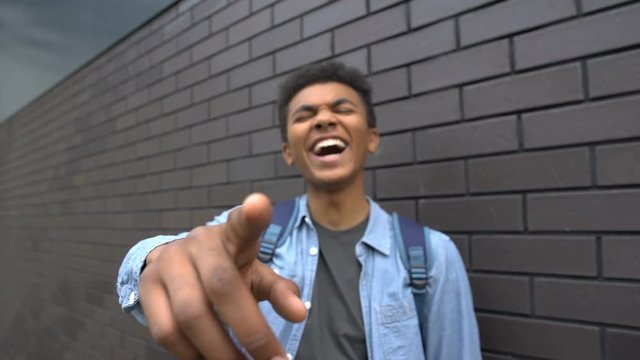 African american teenager mocking into camera, bullying person, victim POV