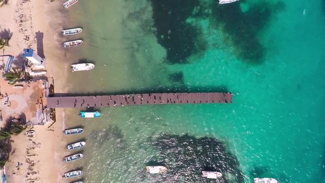 Top view on beach and People walking on wooden bridge. Coast of Caribbean Sea in Puerto Morelos, Yucatan, Mexico