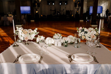 Wedding in the style vintage. Decoration of the table with flowers and cutlery. Composition from flowers. Elegant dining table in peach-purple color. Indoors wedding reception venue with festive decor
