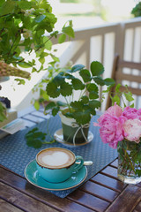 A cup of coffee and flowers on the table