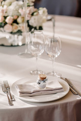 Wedding in the style vintage. Decoration of the table with flowers and cutlery. Composition from flowers. Elegant dining table in peach-purple color. Indoors wedding reception venue with festive decor