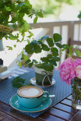 A cup of coffee and flowers on the table