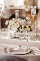 Wedding in the style vintage. Decoration of the table with flowers and cutlery. Composition from flowers. Elegant dining table in peach-purple color. Indoors wedding reception venue with festive decor