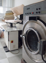 Laundry with a washing machine and  a steam iron press.