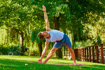Shot of a sporty man doing yoga outdoor