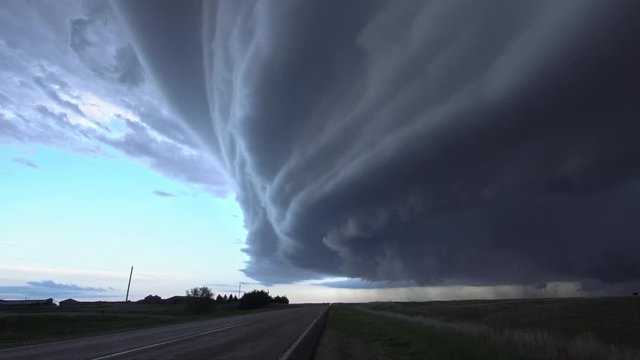 Storm chasing truck drives by as huge storm clouds move overhead bringing severe warnings for tornados and hail in Nebraska.