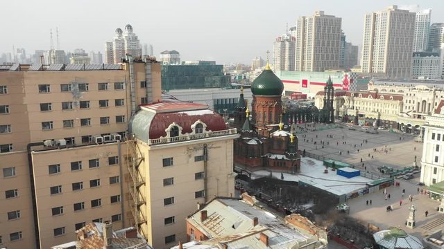 Contrast in China - Revealing drone shot of historic Russian Orthodox Saint Sophia cathedral in downtown Harbin