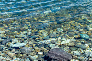 Close view of rocky riverbed under clear fresh water 