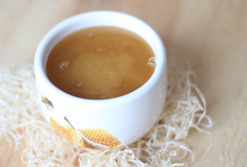 White bowl of honey. Wood table. Rustic style