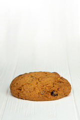 photo of an oatmeal cookie on a white wooden table and an isolated white background. Photo of the dessert for the menu
