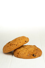 photo of  two an oatmeal cookies on a white wooden table and an isolated white background. Photo of the dessert for the menu
