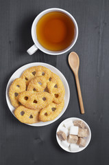 Tea and pretzels with sugar on black