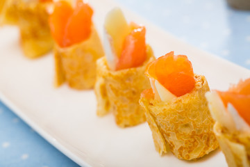 Pancakes rolls with salted salmon on a plate