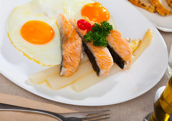 Delicious grilled salmon with eggs, tomatoes, asparagus and parsley
