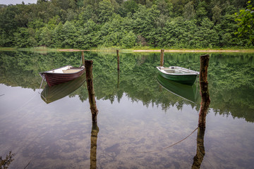 two chained rowboats swimming on a lake