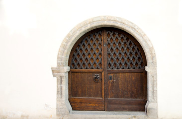 Old wooden gate in the white wall