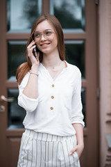 beautiful young woman in a blouse with a phone. businesswoman
