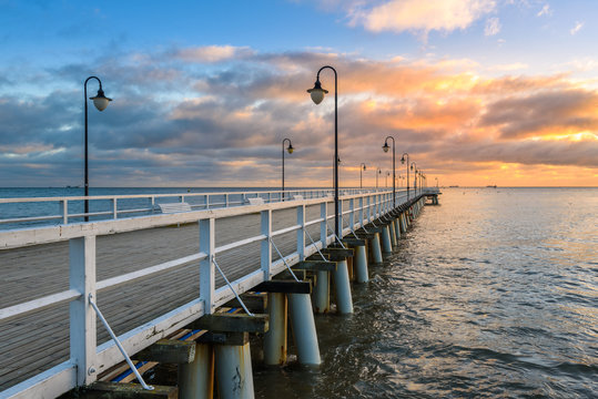 Fototapeta Wooden pier in Gdynia Orlowo in the morning with colors of sunrise. Poland. Europe.
