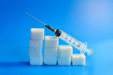 Sugar cubes with syringe. Diabetes concept. The concept of possible harm from sugar. Increase in...