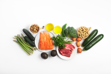 Ketogenic, keto diet, including vegetables, meat and fish, nuts and oil on white background