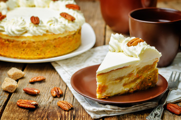 carrot cake cheesecake with pecan on a wood background