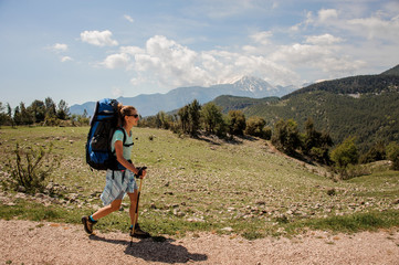 Female hiker travelling up the road in hills