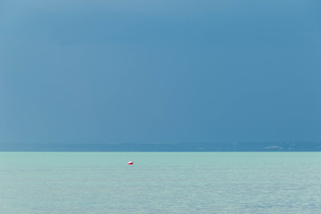 Naklejka premium Water landscape with one buoyunder the dark blue sky