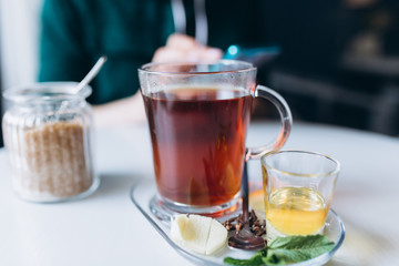 Hot tea in cafe with honey, spices, mint, lemon and ginger. Breakfast, relax concept