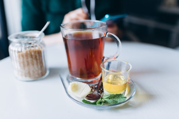 Hot tea in cafe with honey, spices, mint, lemon and ginger. Breakfast, relax concept