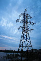 power line tower on the lake against the sky