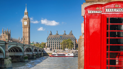 Fototapeta premium Symbole Londynu, Big Ben i czerwone budki telefoniczne z łodzią na rzece w Anglii, Wielkiej Brytanii