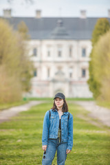 tourist woman posing on alley to old castle