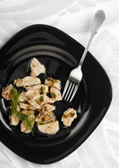 Lazy dumplings watered with green sauce with a fork on a dark plate on a textured light background. Traditional In the Chechen, Ingush and Balkar they are called Zhur-healthmash.
