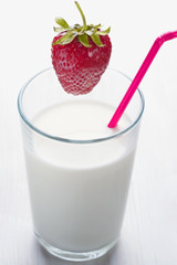  juicy strawberries falling into milk 