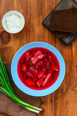 Borsch in a plate on a wooden table. Traditional, national russian soup.