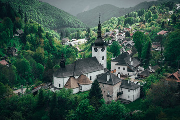 View on historical mining settlement in Slovakia, village Spania Valley with church surrounded by green forests and hills, summer day - obrazy, fototapety, plakaty