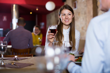 Glad girl with man enjoying meal at restaurant
