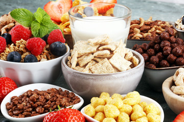 Cereal. Bowls of various cereals, berries and milk for breakfast. Muesli with kids cereals.