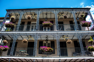 Beautiful Hot Pink Geraniums Bloom in Flower Baskets Hanging from a Two Story Wrought Iron Balcony in the French Quarter of New Orleans, Louisiana, USA