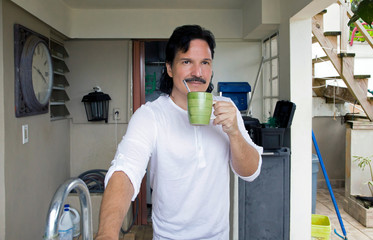 Hispanic man drinking beverage from his home - 272884036