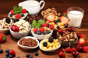 Cereal. Bowls of various cereals, berries and milk for breakfast. Muesli with kids cereals.